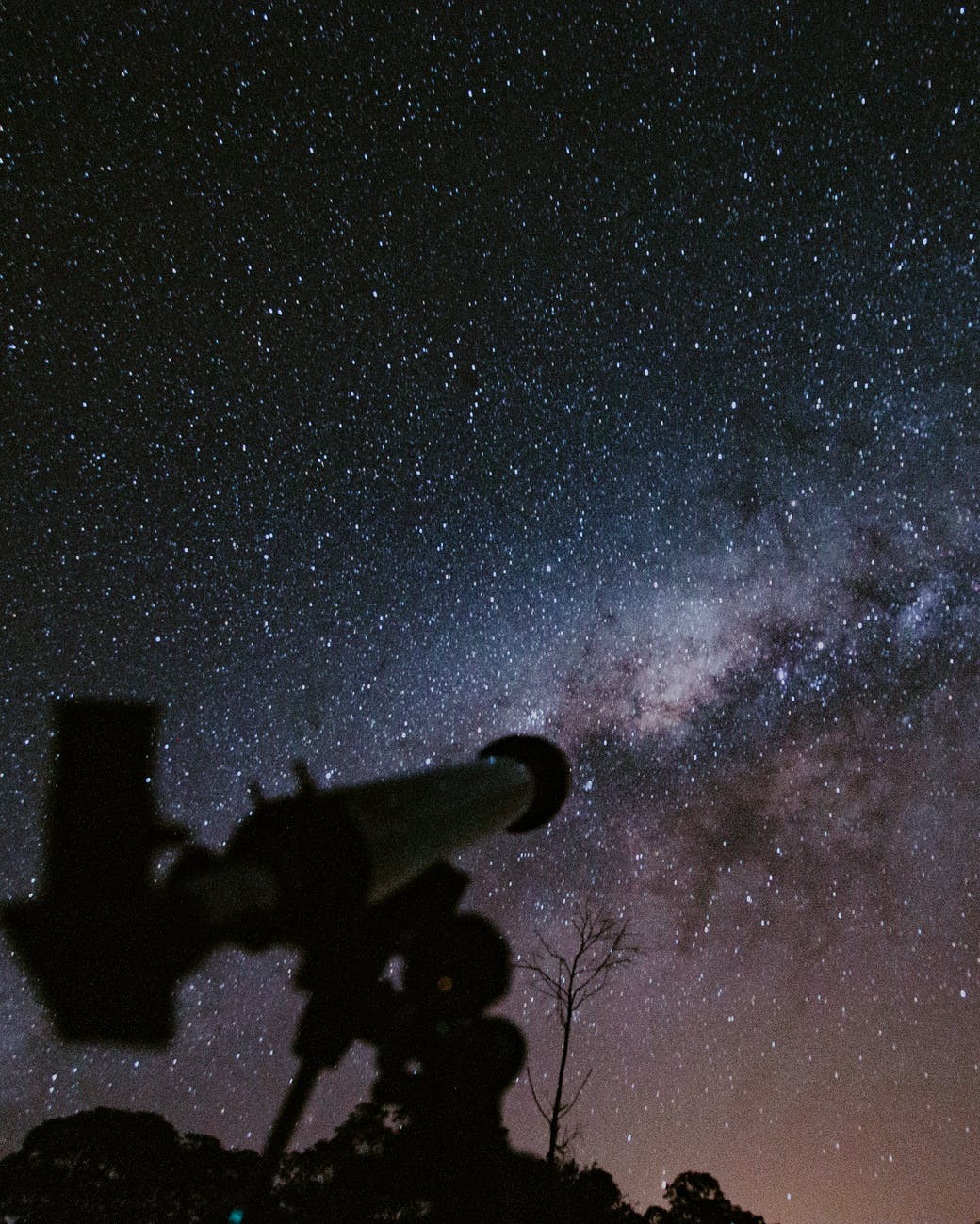 telescope pointing at milky way galaxy at night